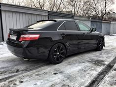 a black car is parked in the snow