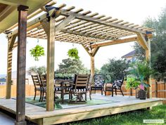 an outdoor dining area with table and chairs under a wooden pergolan roof, surrounded by greenery