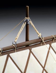 a close up view of the top of a boat's mast with ropes attached to it