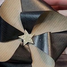 a close up of a person holding a black and white bow with a star on it