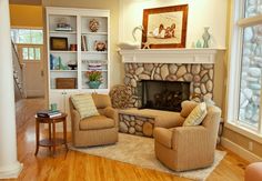 a living room filled with furniture and a fire place under a painting on the wall