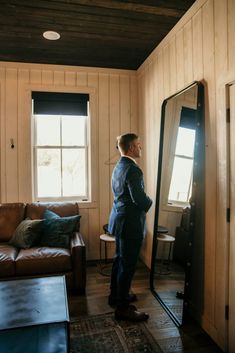 a man standing in front of a large mirror