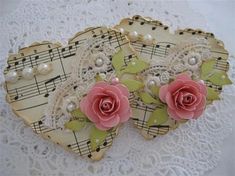 two pieces of paper with flowers and pearls on top of sheet music notes are sitting on a lace doily