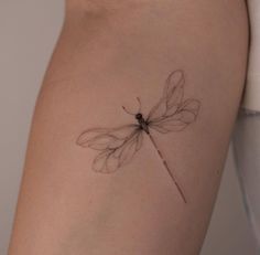 a small dragonfly tattoo on the right thigh