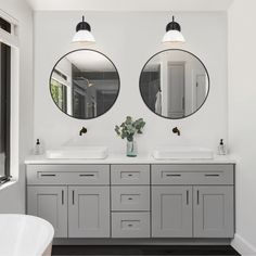 a bathroom with two sinks and mirrors on the wall