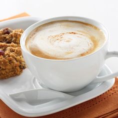 a cup of coffee and some cookies on a plate