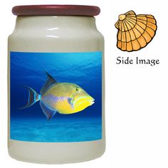 a jar with an image of a fish on the front and bottom, next to a sea shell