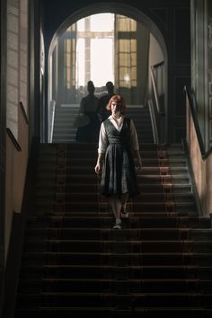 a woman is walking down some stairs