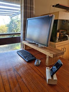 a computer monitor sitting on top of a wooden desk next to a keyboard and mouse