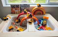 the toys are in the sandbox on the table