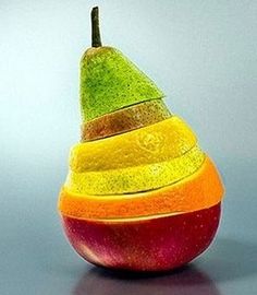 an orange, yellow and green apple sitting on top of a black table with grey background