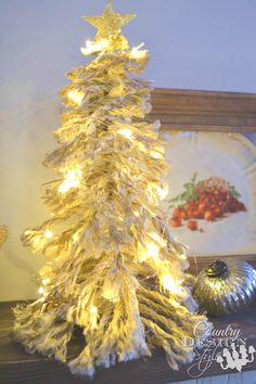 a white christmas tree sitting on top of a mantle