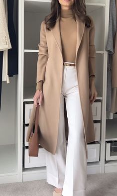 Step into sophistication with this refined outfit. Featuring a camel-toned turtleneck and a matching long coat, paired seamlessly with crisp white tailored trousers. The ensemble is complemented by a structured brown leather handbag and subtle accessories, creating a polished look perfect for transitional seasons. Effortless chic for any occasion! Camel Turtleneck Outfit, Long Camel Coat Outfits, Brown Long Coat Outfit, Leggings Street Style, Street Style Handbags, Long Camel Coat, Look Office