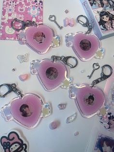 some pink heart shaped key chains with pictures on them