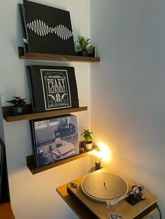 a record player sitting on top of a wooden table next to a wall mounted cd player