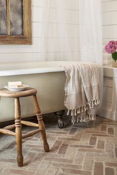 an instagram page with a bathtub and stool in the corner, on top of a tile floor