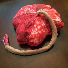 a red hat sitting on top of a wooden table next to a piece of cloth