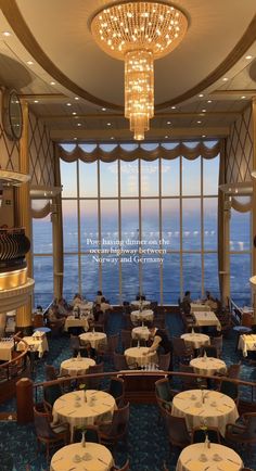 the dining room is overlooking the ocean and has chandeliers hanging from the ceiling