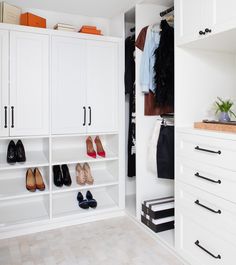 an organized closet with white cabinets and shoes