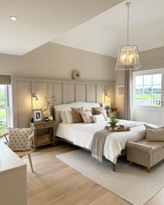 a bedroom with a large bed and two lamps hanging from the ceiling over it's headboard