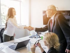 two people shaking hands in an office setting