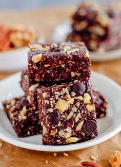 three pieces of chocolate brownie on a plate with nuts and pecans around it