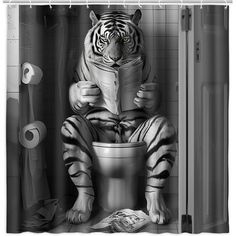 a black and white photo of a tiger sitting on a toilet