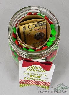 a jar filled with candy and money sitting on top of a table next to a card