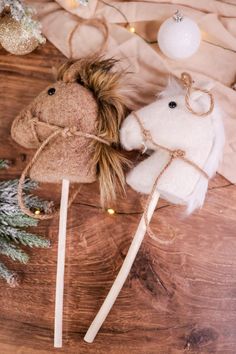 two small stuffed animals on top of wooden sticks