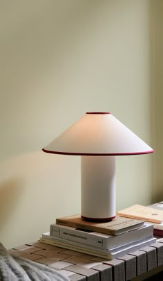 a lamp sitting on top of a stack of books