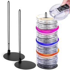 a stack of different colored discs next to a black stand with one disc in it