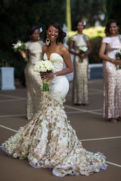 a woman in a wedding dress holding a bouquet and standing next to other bridesmaids