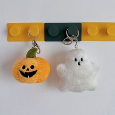 two key chains that have been made to look like ghost and pumpkins