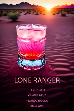 a pink and blue drink sitting in the middle of a desert with mountains in the background