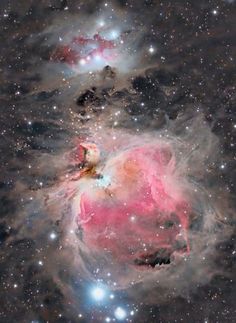 two stars in the middle of a space filled with stars and dust, one is pink