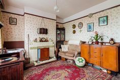 an old fashioned living room with floral wallpaper