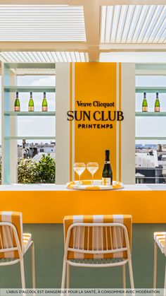 the sun club printemps sign is displayed in front of two chairs with wine glasses on them