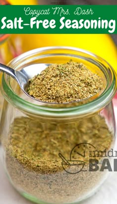 a glass jar filled with seasoning sitting on top of a table