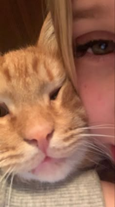 a close up of a person with a cat on their shoulder and the face of a cat