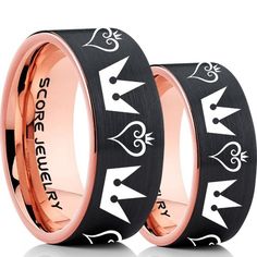 two black and rose gold wedding rings with crowns on each side, one has the word love