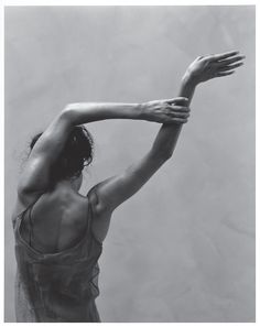 a black and white photo of a woman stretching her arms