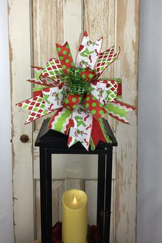 a lighted candle sits in front of a wooden door decorated with paper flowers and ribbons