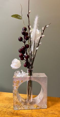 a glass vase with flowers and feathers in it