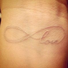 a woman's wrist tattoo with an infinite symbol on the left side of her arm