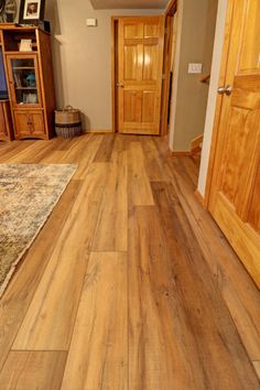 an empty room with wood flooring and wooden doors in it's center area