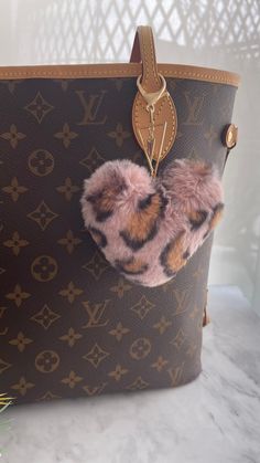 Fluffy Faux Fur Heart Shaped  Pompom Bag Charm. Soft and Luxurious feeling. Pink leopard print, hanging from a V shaped gold charm.  Perfect way to elevate and accessorize your handbag. Purse Charm Care🤎 ✨Use as an accessory for your bag and not a keychain, as it will maintain its beauty & longevity that way. ✨To keep your purse charm in its best condition: ✨Avoid water, sprays and oils ✨Metals fade naturally over time. Use a cloth with a little bit of lemon juice to polish and bring back shine Pink And Brown, Pink Leopard Print, Letter V, Brown Leopard, Leather Bows, Crystal Charm, Pink Leopard, Purse Charms, Charm Gift