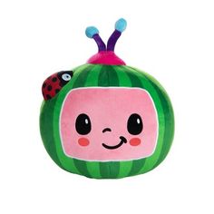 a green and pink stuffed animal with two ladybugs on it's head