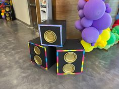 there are speakers made out of cardboard boxes on the floor next to balloons and streamers