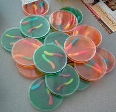 several plastic cups with toothbrushes in them sitting on a table next to books