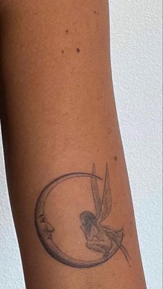 a woman's arm with a small tattoo on it